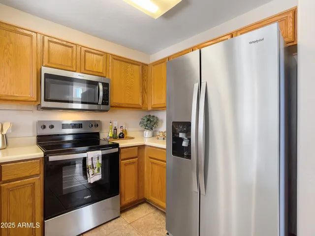 a kitchen with stainless steel appliances granite countertop a refrigerator stove and microwave