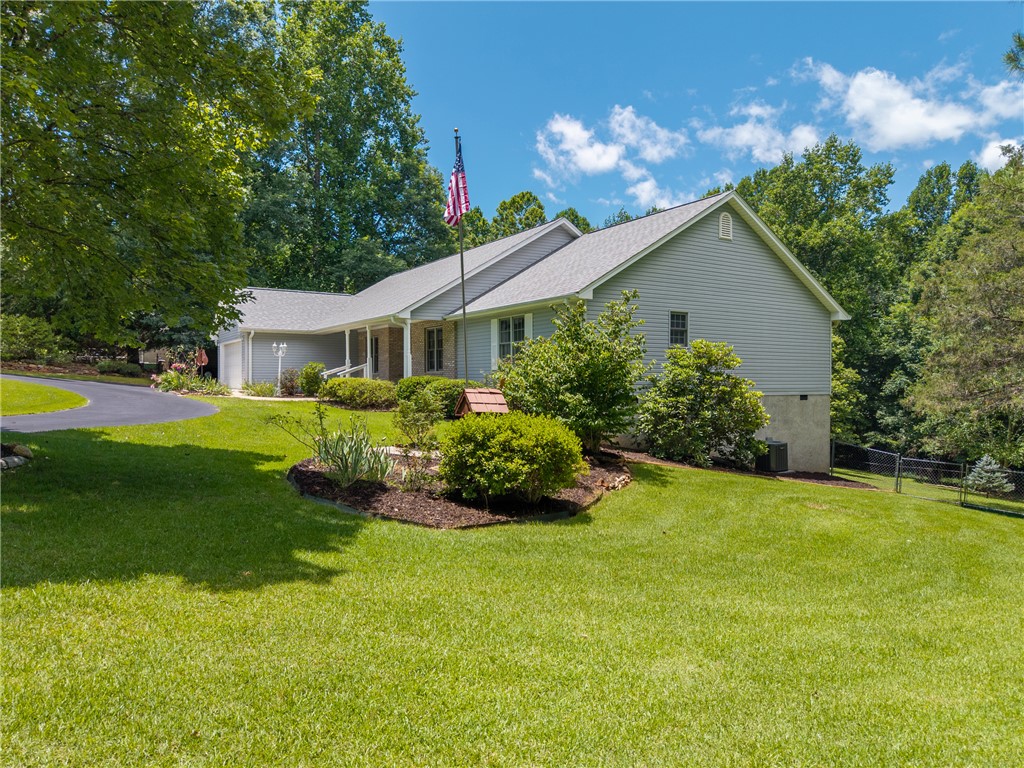 429 Burns Mill Road West Union, SC 29696 - Photo 43 of 49 A graceful home nestled amidst mature trees, featuring a paved driveway and verdant landscaping.