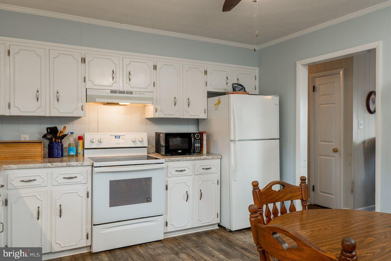 1204 Battle Creek Road Stanley, VA 22851 - Photo 14 of 46 a kitchen with white cabinets and white appliances