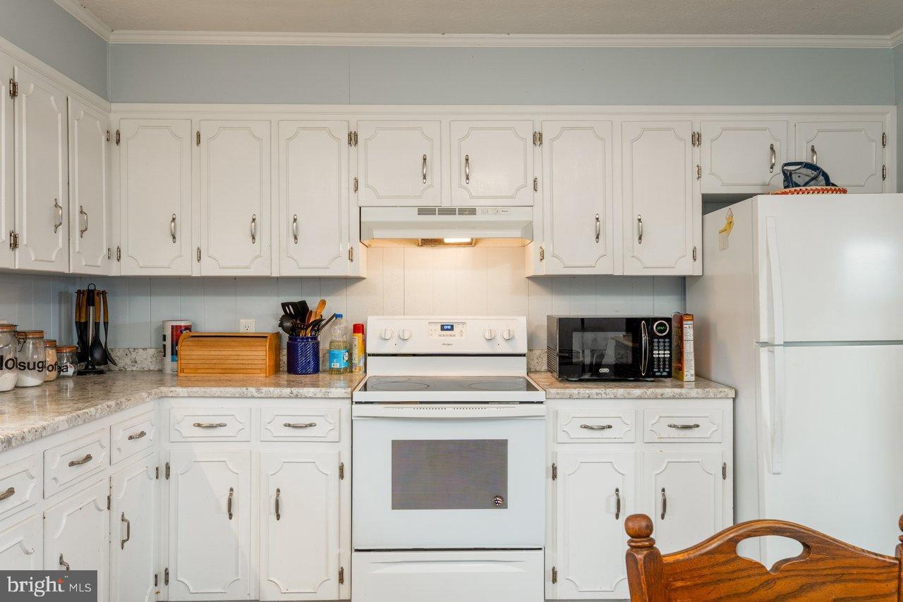 1204 Battle Creek Road Stanley, VA 22851 - Photo 15 of 46 a kitchen with granite countertop white cabinets and white appliances