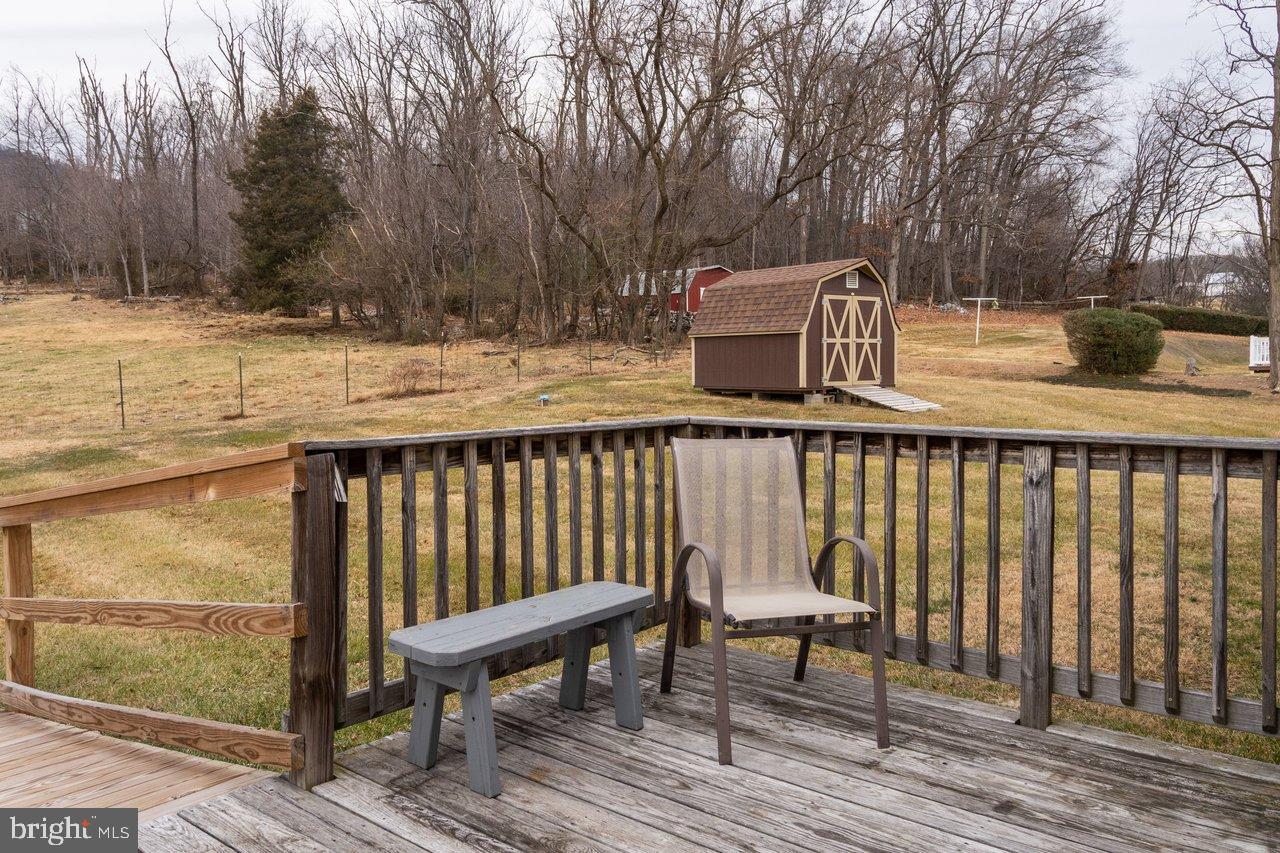 1204 Battle Creek Road Stanley, VA 22851 - Photo 37 of 46 a view of a roof deck with table and chairs with wooden floor and fence