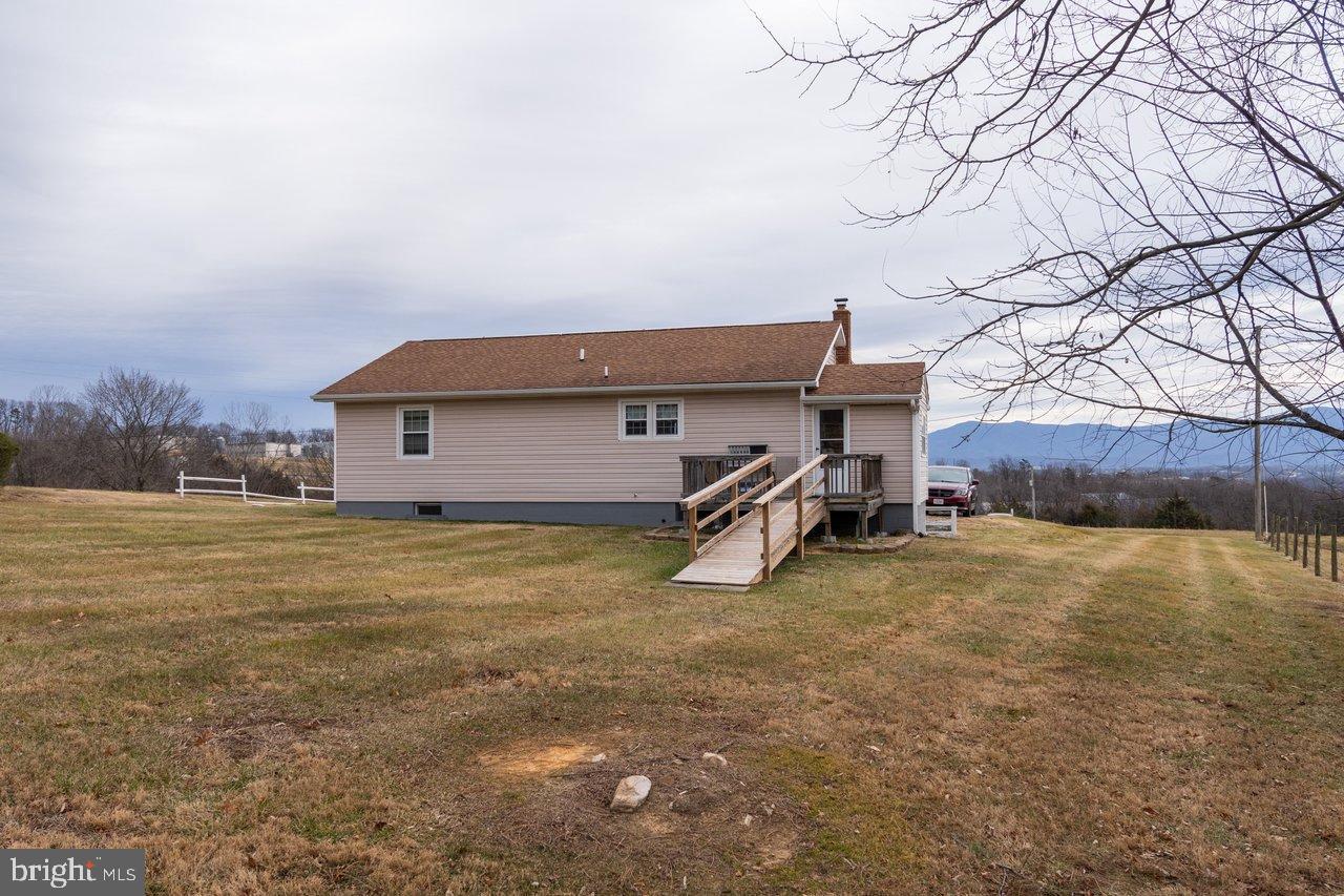 1204 Battle Creek Road Stanley, VA 22851 - Photo 42 of 46 a backyard of a house with table and chairs under an umbrella