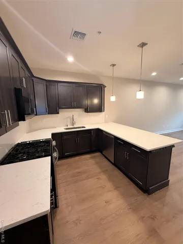 a kitchen with stainless steel appliances granite countertop a sink a stove and a refrigerator