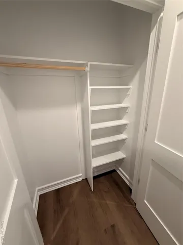 a view of walk in closet with empty racks