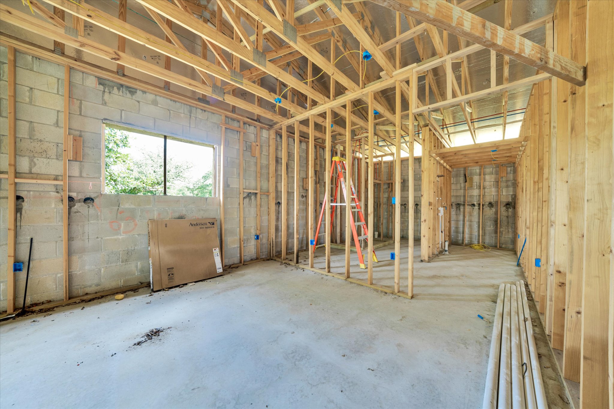 2755 Washburn Road Luling, TX 78648 - Photo 28 of 40 Witness the early stages of a residential project, showcasing robust wooden framing and solid concrete block walls.