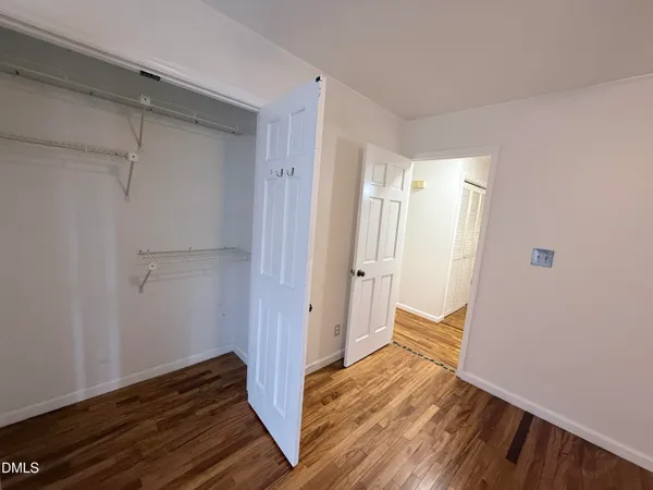 a view of empty room with wooden floor