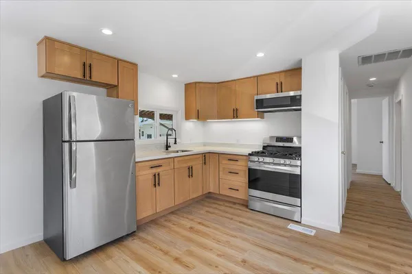 a kitchen with stainless steel appliances granite countertop a refrigerator sink and stove