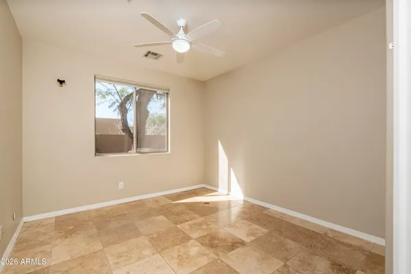 an empty room with fan and windows