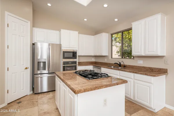 a kitchen with stainless steel appliances granite countertop a refrigerator sink and stove