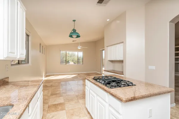 a kitchen with kitchen island granite countertop a sink stove and cabinets
