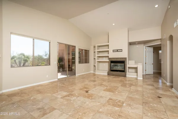 a view of an empty room with a fireplace and a window