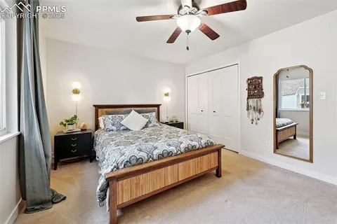 a bedroom with a bed and a mirror on dresser