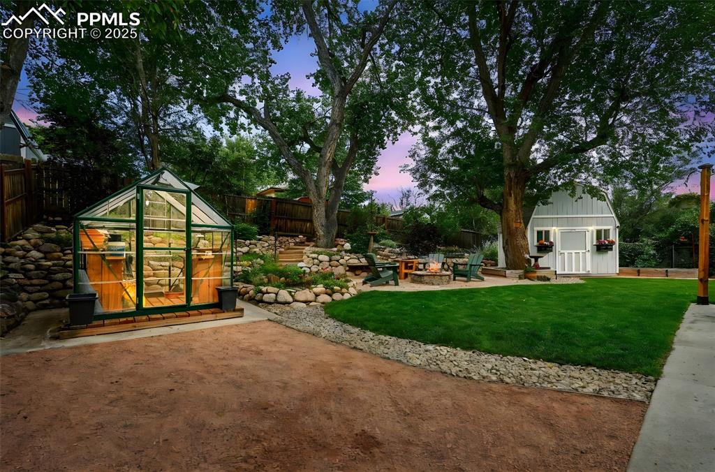 5139 Villa Circle Colorado Springs, CO 80918 - Photo 26 of 40 a view of a park with large trees and a wooden fence