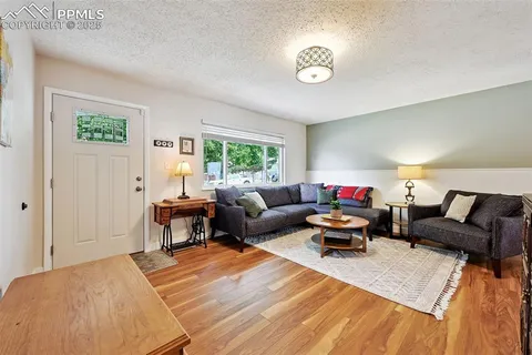 a living room with furniture and a wooden floor