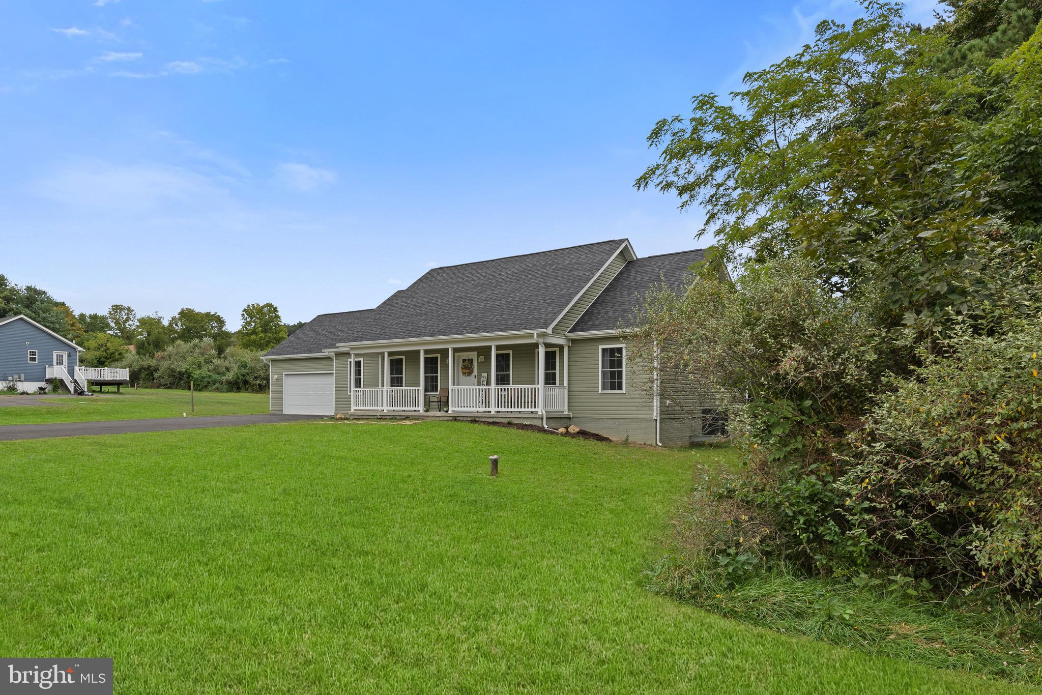 61 MDG Court Berkeley Springs, WV 25411 - Photo 12 of 47 a house that is sitting in the grass with large trees and plants