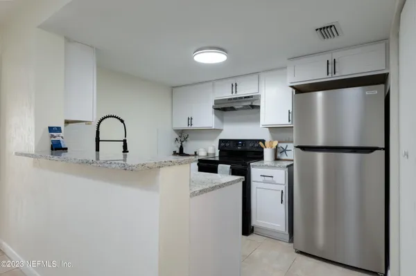 a kitchen with stainless steel appliances granite countertop a refrigerator a sink and a stove
