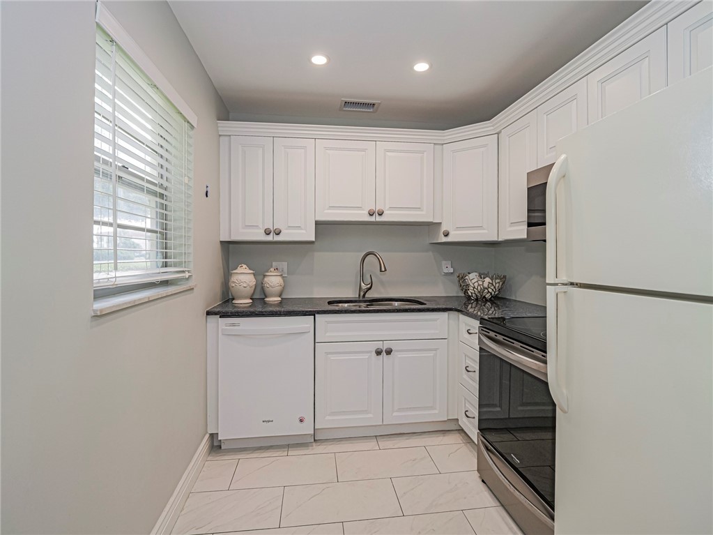 5400 Highway A1a, Unit D3 Vero Beach, FL 32963 - Photo 9 of 35 a kitchen with granite countertop white cabinets and stainless steel appliances