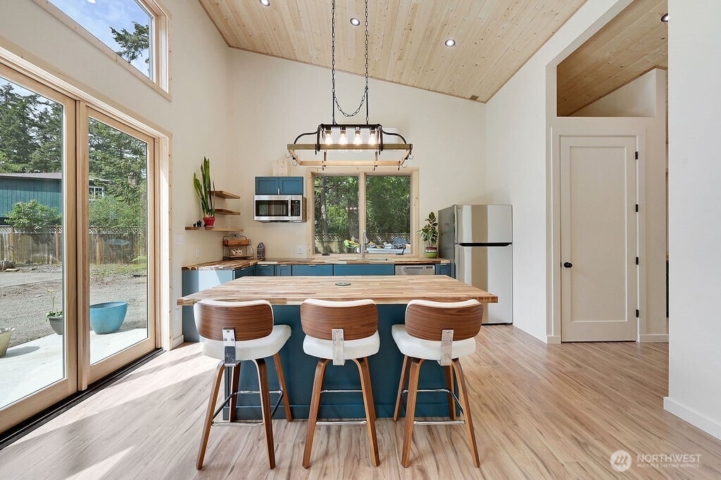 196 Nolton Road Nordland, WA 98358 - Photo 24 of 39 a dining room with stainless steel appliances a table and chairs