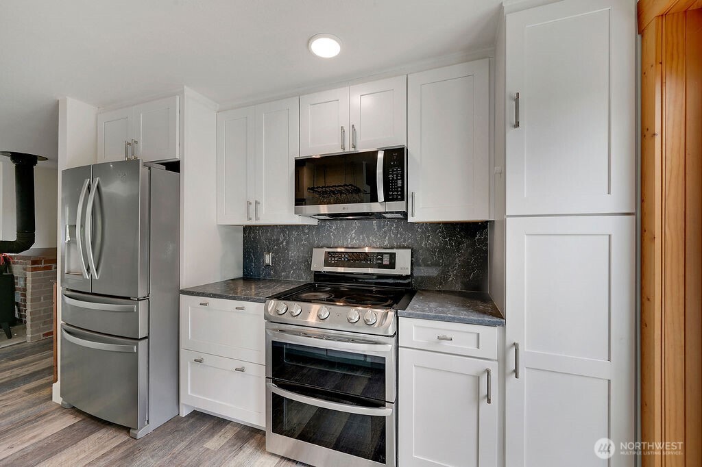 196 Nolton Road Nordland, WA 98358 - Photo 6 of 39 a kitchen with a refrigerator stove and microwave