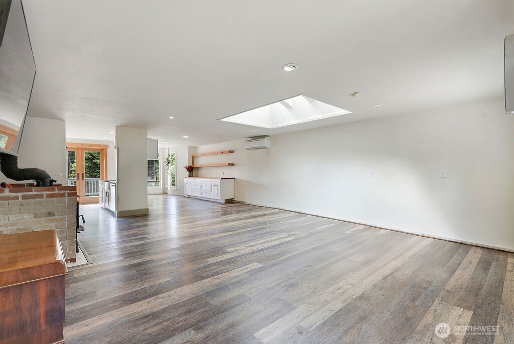 196 Nolton Road Nordland, WA 98358 - Photo 10 of 39 an empty room with wooden floor and a kitchen
