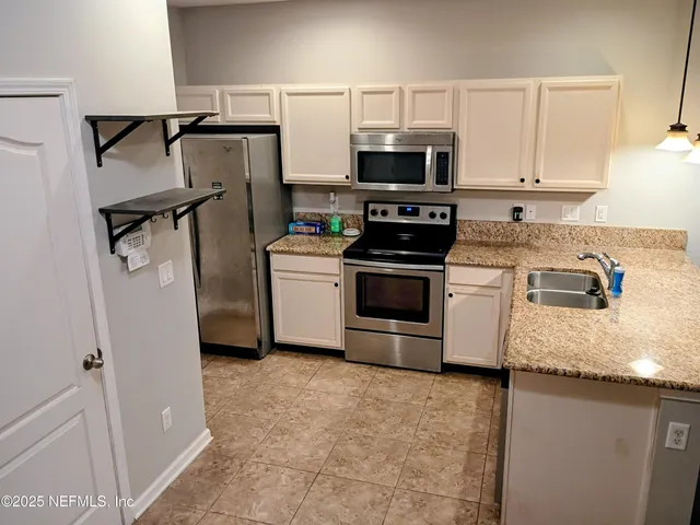a kitchen with kitchen island a stove a sink and a microwave
