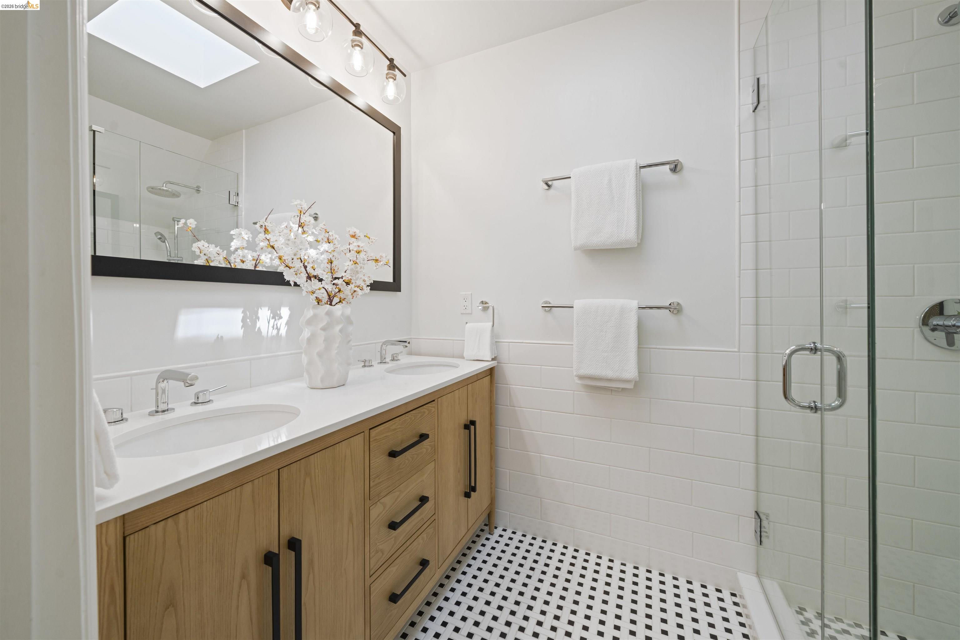 1170 Sterling Avenue Berkeley, CA 94708 - Photo 29 of 52 Full bath with double vanity, a shower stall, tile walls, and a wainscoted wall