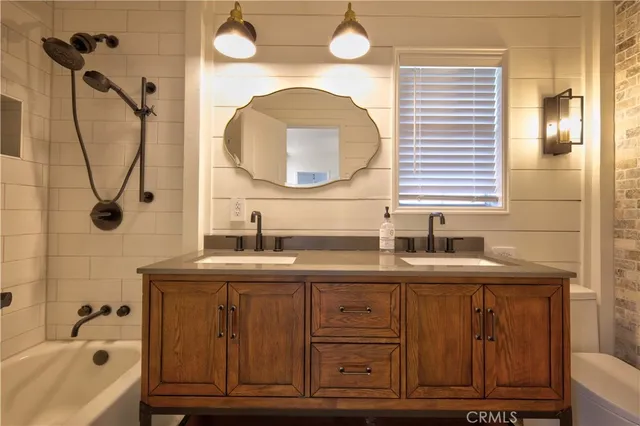 a bathroom with a granite countertop sink a mirror a vanity and bathtub