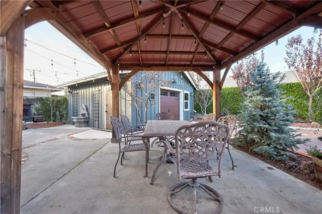 a patio with table and chairs and potted plants