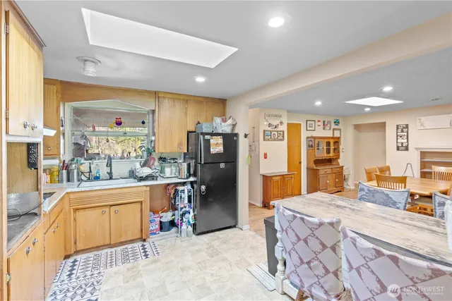 a large kitchen with stainless steel appliances kitchen island granite countertop a refrigerator and a stove