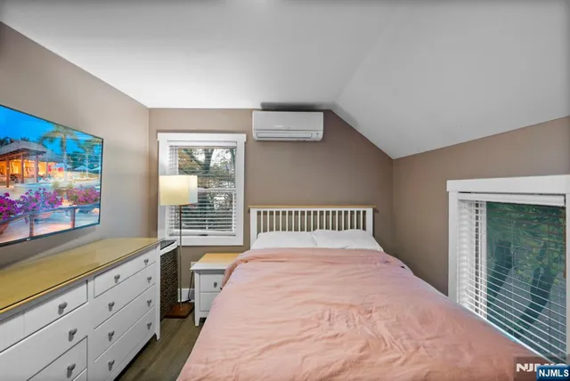 a bedroom with a large bed and a flat tv screen on dresser