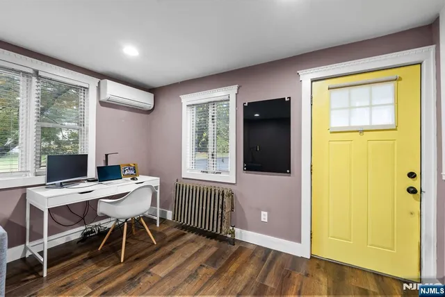 a view of a workspace with furniture and a window
