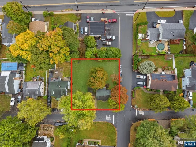 an aerial view of a residential apartment building with a yard and outdoor seating