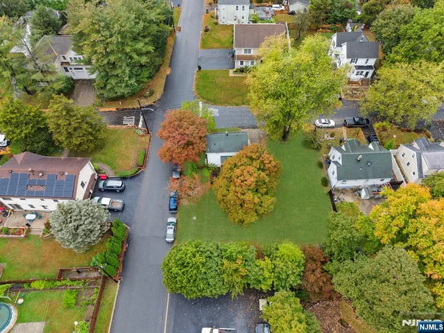an aerial view of residential houses with outdoor space and swimming pool