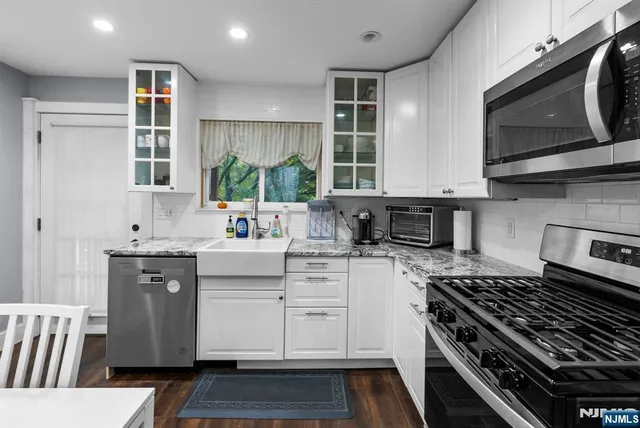 a kitchen with stainless steel appliances a sink dishwasher stove microwave and cabinets