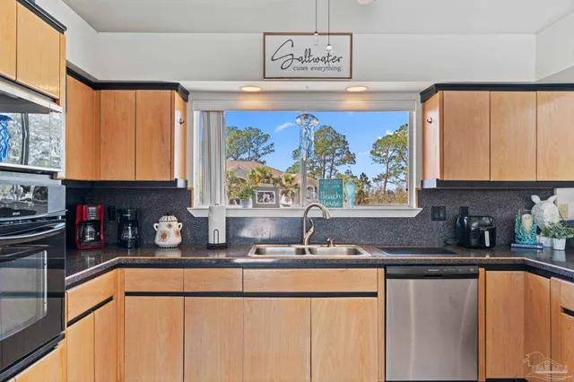 a kitchen with stainless steel appliances a sink window and cabinets
