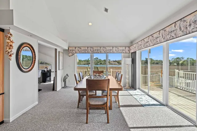 a dining room with furniture and a large window