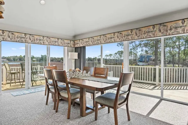 a view of a dining room with furniture large windows and wooden floor