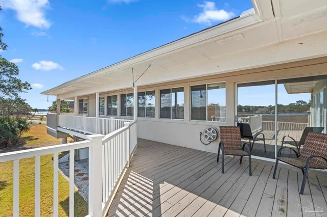 a view of a house with wooden deck and furniture