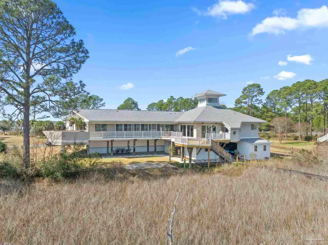 a view of a house with a big yard and large trees