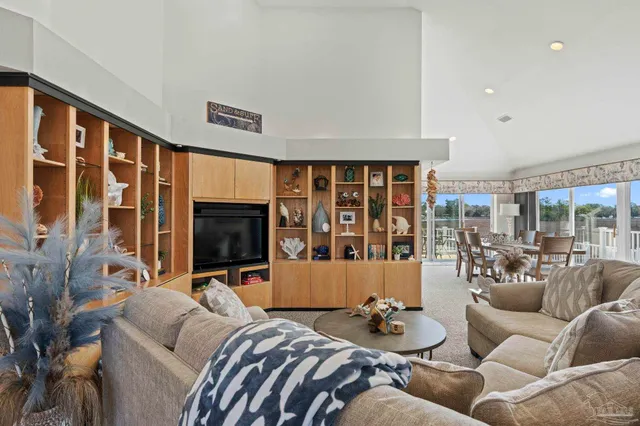 a living room with furniture large window and flat screen tv