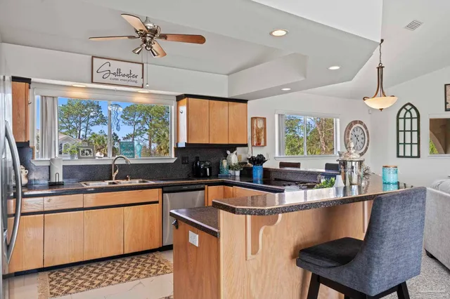 a kitchen with a sink a window cabinets and stainless steel appliances