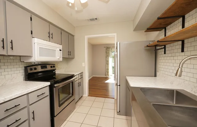 a kitchen with a sink a stove and cabinets
