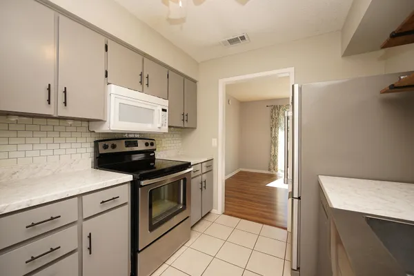 a kitchen with a stove sink and cabinets