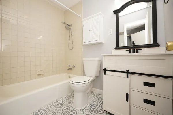 a bathroom with a sink toilet a mirror and bathtub