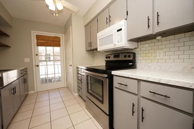 a kitchen with granite countertop white cabinets stainless steel appliances and sink