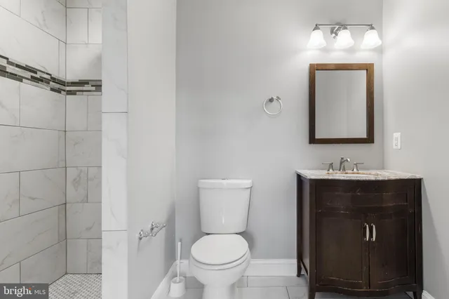 a bathroom with a toilet sink and mirror