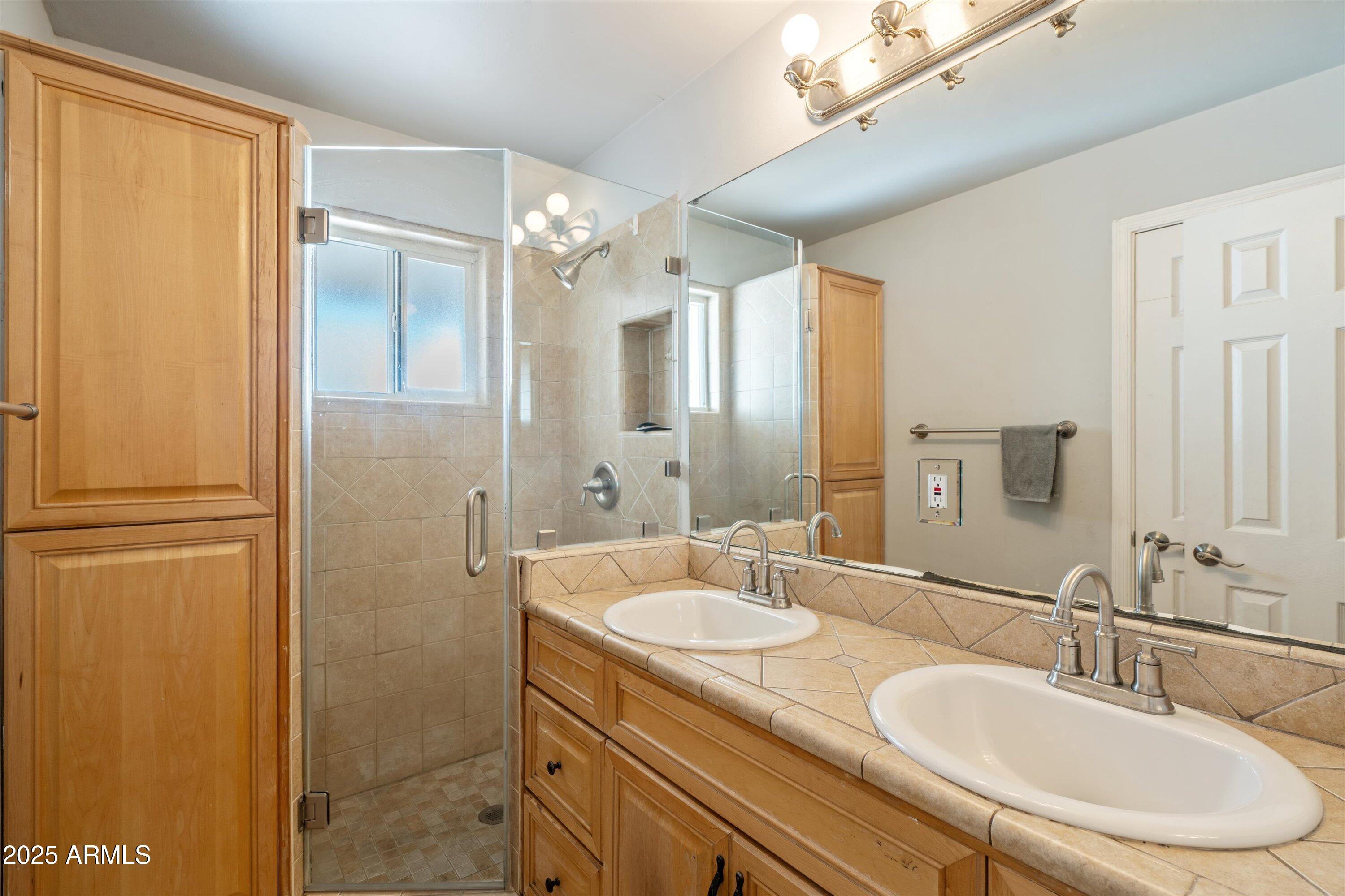 8216 North 9th Street Phoenix, AZ 85020 - Photo 15 of 38 a bathroom with a granite countertop sink a mirror and a shower