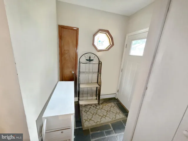 a view of a hallway with entryway wooden floor and front door