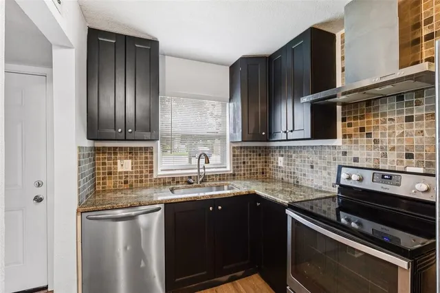 a kitchen with stainless steel appliances granite countertop a sink stove and refrigerator