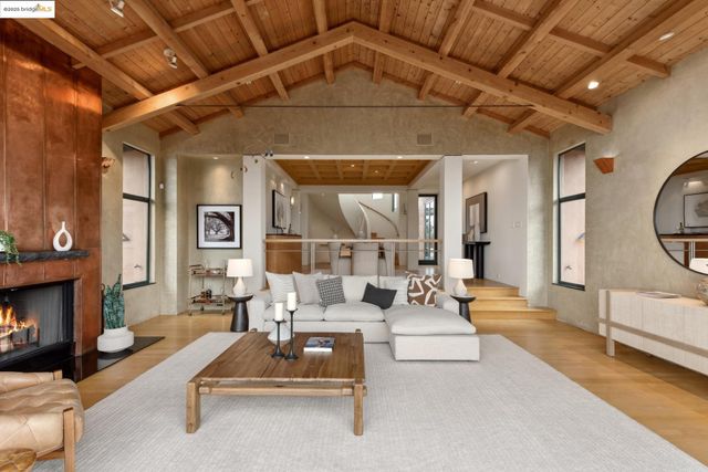 a kitchen with stainless steel appliances kitchen island granite countertop a stove a refrigerator a sink a dining table and chairs with wooden floor